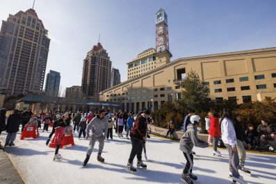 Full screen view of people enjoying skating on an outdoor skating rink,