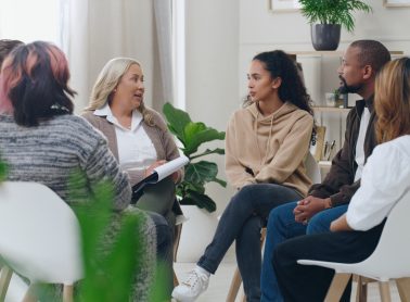 Full view of people sitting in a circle chatting
