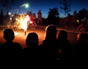 Group of people watching one firework on the ground.