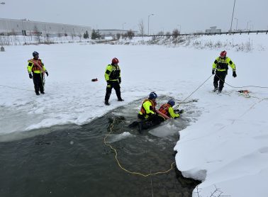 Full view fire safety training happening in the water with ice