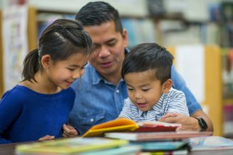 A family reading books at a table.
