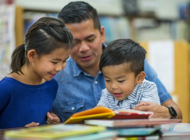 A family reading books at a table.