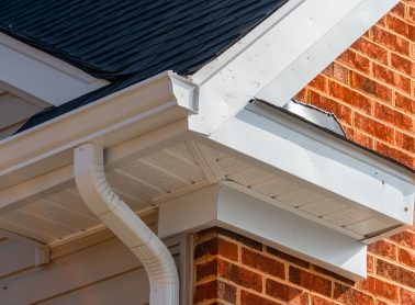 Red brick home with a white eavestrough.