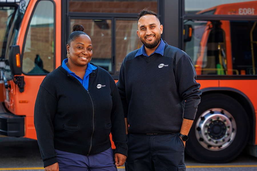 Two MiWay employees standing in front of a bus