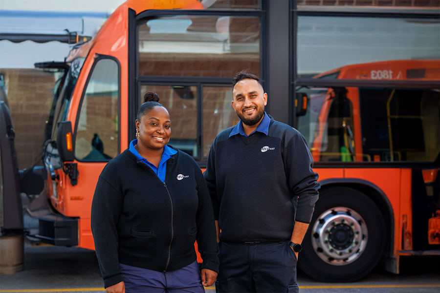 Two MiWay employees standing in front of a bus