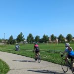 Two cyclists riding their bikes on park trail