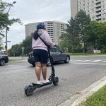 Person on an e-scooter riding on the road