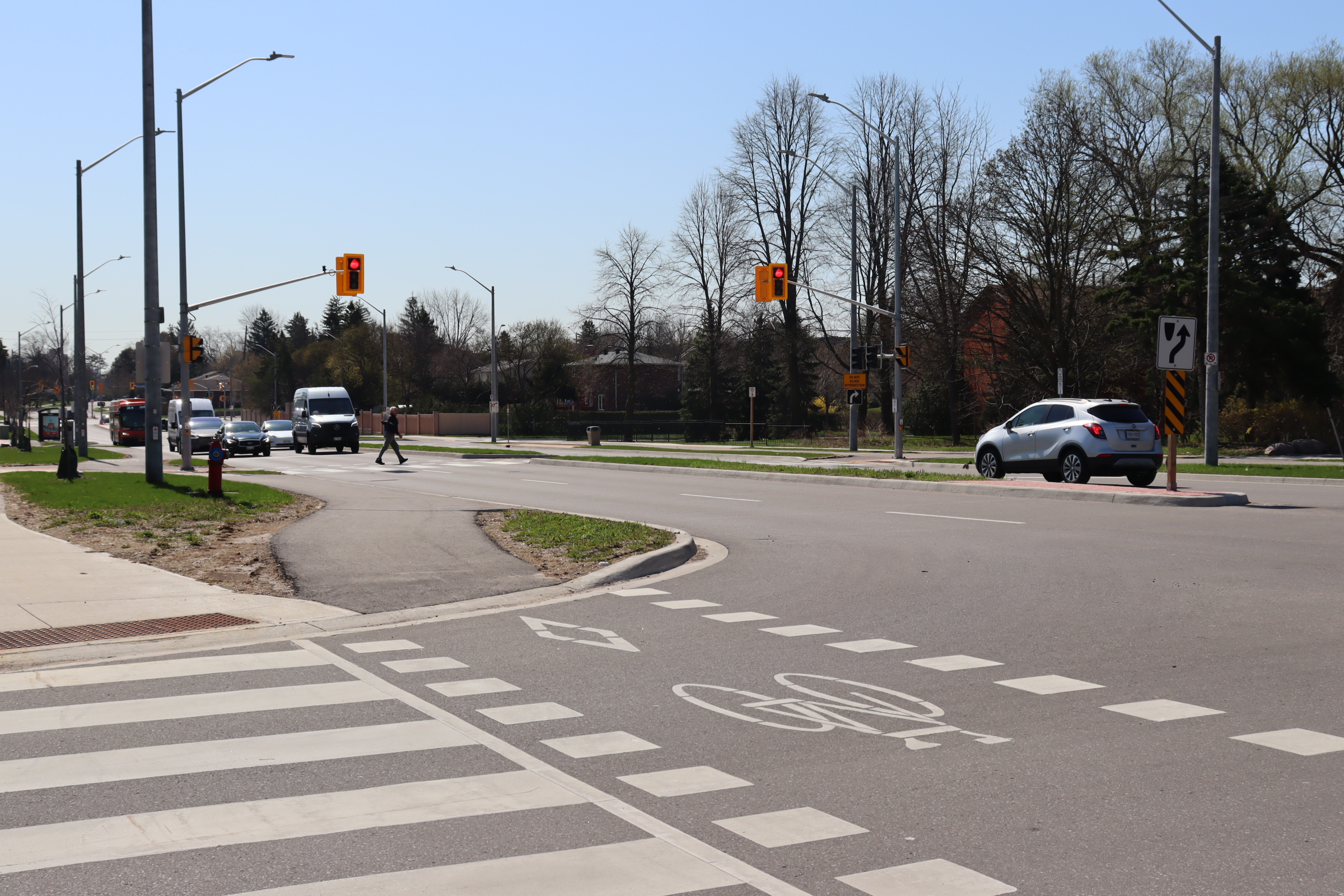A pedestrian using a mid-block pedestrian signal crossing.