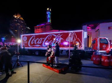 Coca‑Cola holiday truck display with Santa photo area at Light Up the Square event.