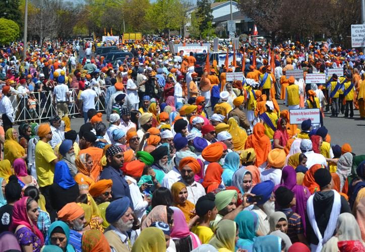 People standing in bright colours enjoying the Khalsa Day (Nagar Kirtan) Parade in Malton