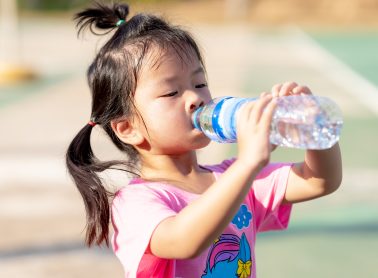 A child drinking water from a water bottle.