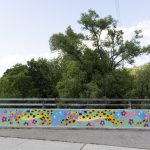 Mural painted on the retaining wall over the Cooksville Creek depicting colourful jaguars leaping and running.