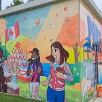 Colourful mural on square storage hut depicting people from Port Credit enjoying the outdoors at a party.