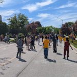 Many children of all ages play on a road that has been closed to vehicle traffic.