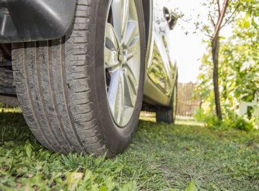 Car in the Parking lot on the grass, rear wheel close-up. Selective focus, outdoor, summer