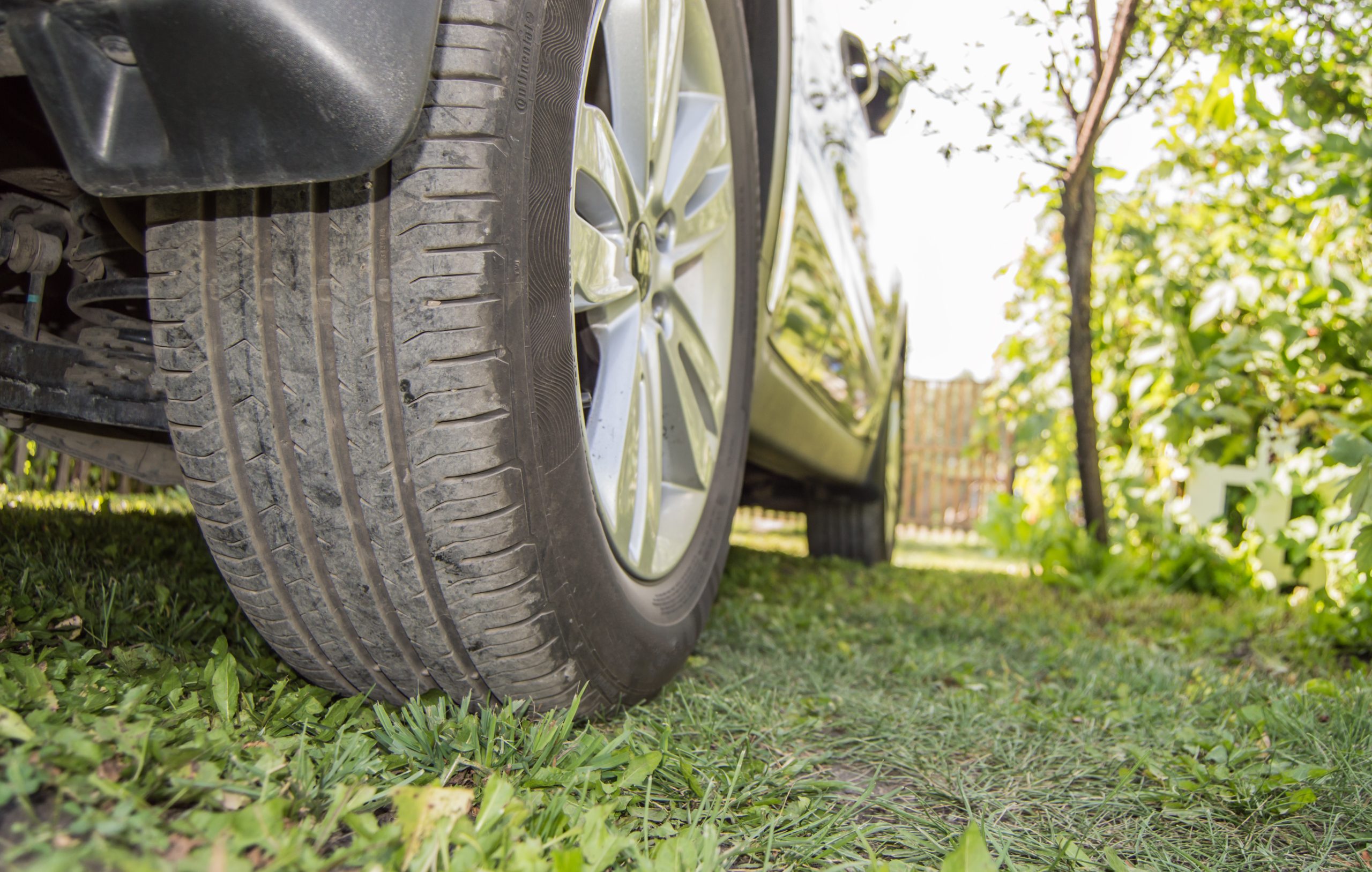 Car in the Parking lot on the grass, rear wheel close-up. Selective focus, outdoor, summer