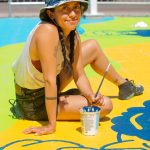 Artist, Vivian Rosas, painting a mural called, Blissful Release.