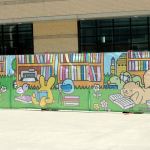A mural of cartoon animals reading books.