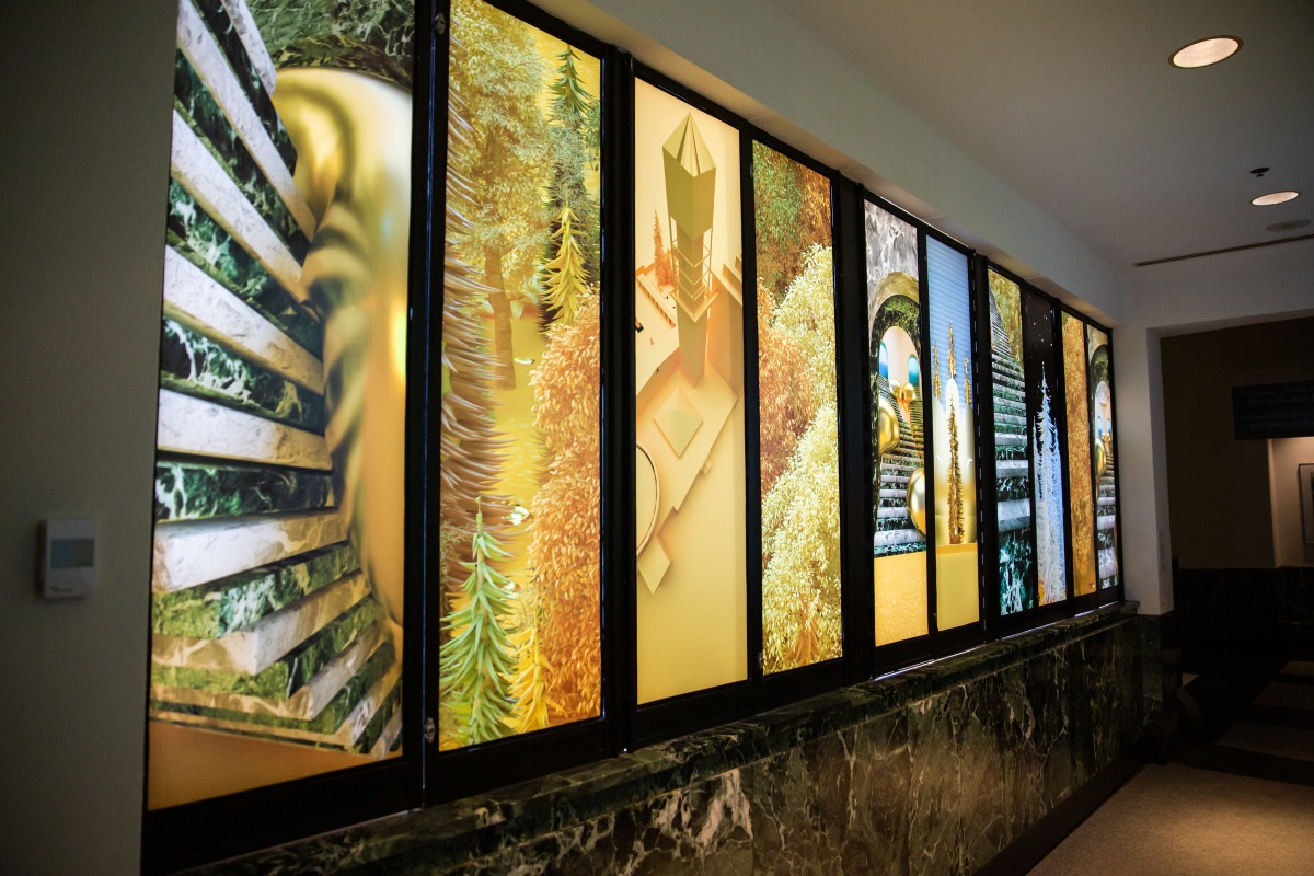 Ten panels with printed images of landscapes on them inside a hallway