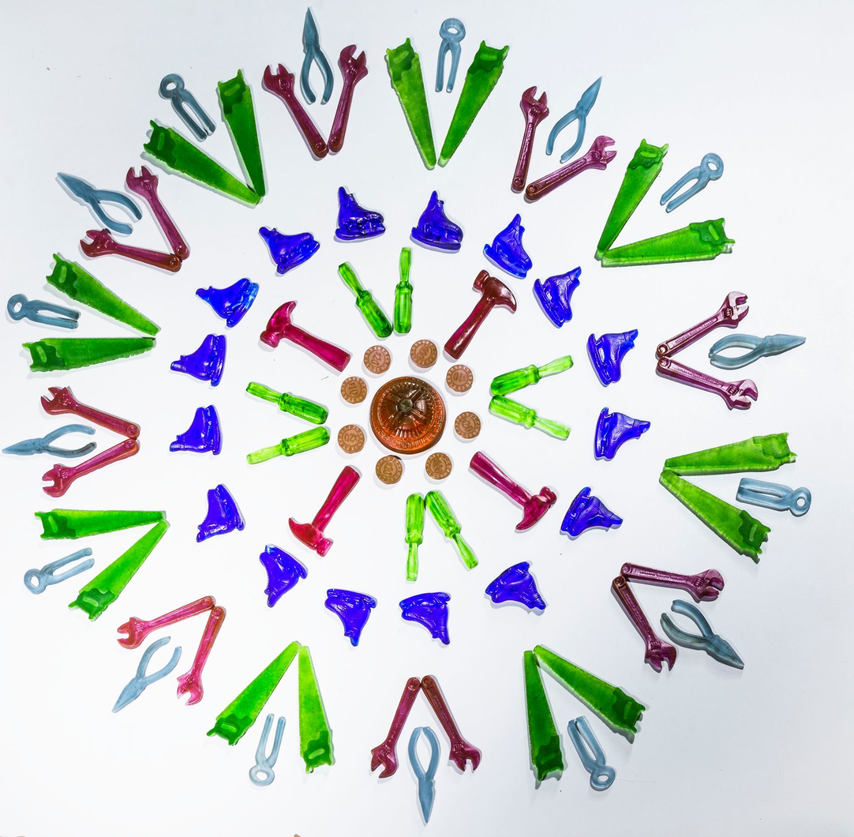 White, green, red and blue pieces of glass arranged in a circular, mandala.