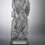 Grey glass sculpture of a goddess.