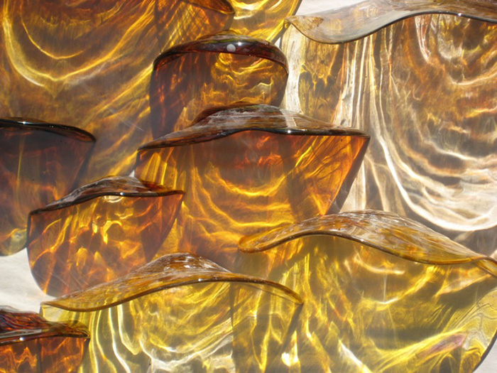 Glass sculpture made of wavy amber glass.