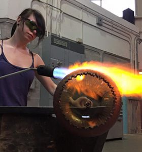 A woman using a blow torch.