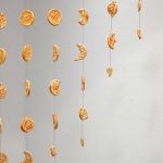 A curtain of ceramic beads that are shaped like orange slices.