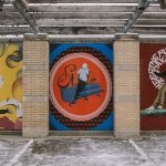 An exterior wall with a mural depicting people performing break dance moves.