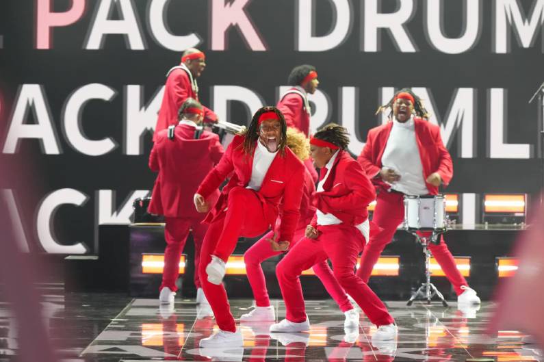The Pack Drumline promo photo on stage in red costumes