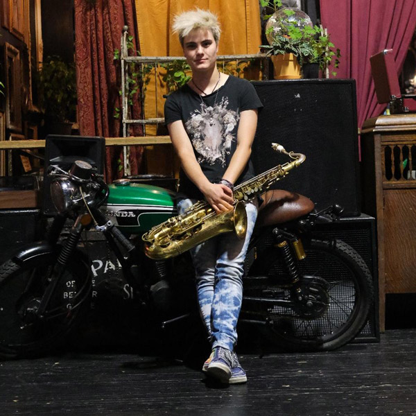 Kristen Prince holding a saxophone in a music studio.