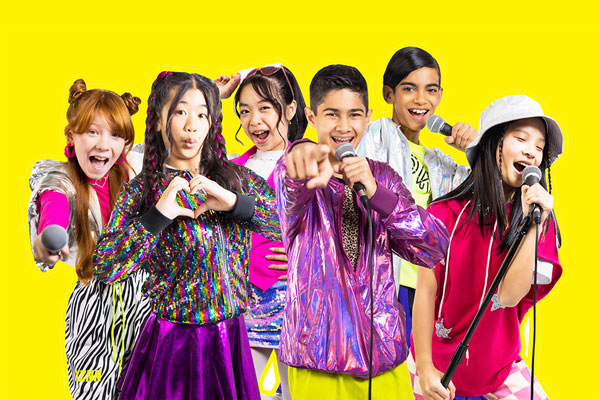 Mini Pop performers with a yellow background.