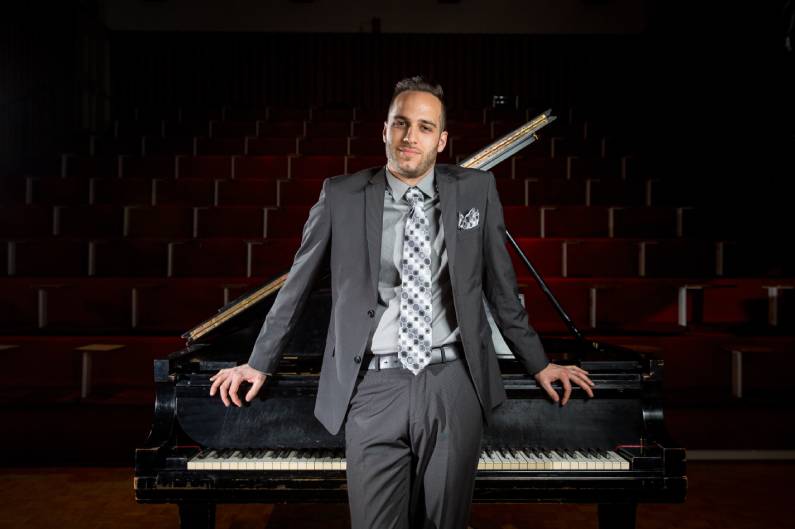 artist Carmen Spada in front of a grand piano on a stage