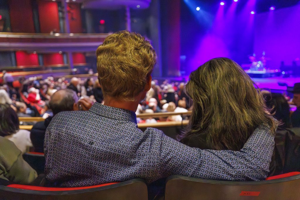 Couple waiting for show to start in theatre