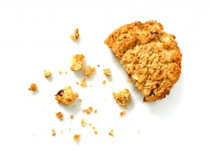 Oatmeal cookie with crumbs isolated on white background. Top view.