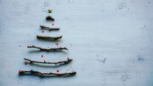 Christmas fir made reusing wooden sticks on a simple light blue background