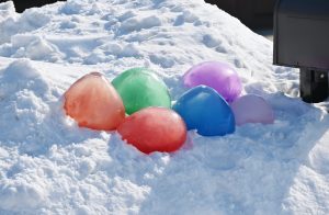 Six frozen water balloons in snow