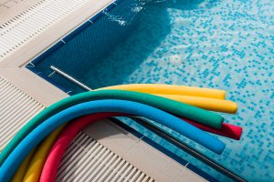 top view of colorful pool noodles near swimming pool