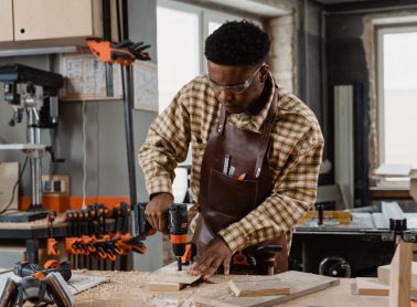 Man drilling wood in woodworking studio