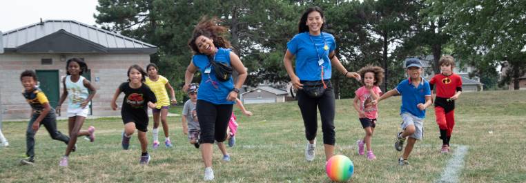 camp leaders and kids kicking a ball