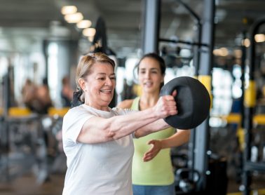 Adult lady working out with a trainer at the gym