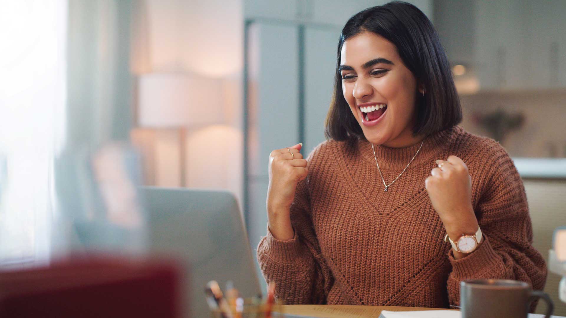 Excited student looking at a laptop