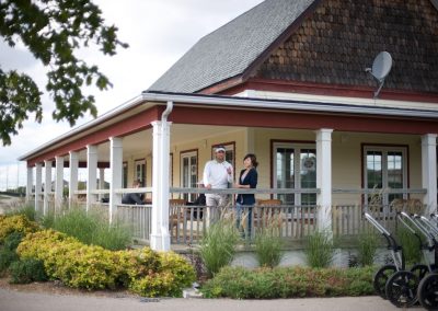 Two golfers on the BraeBen 9-Hole Course clubhouse veranda.