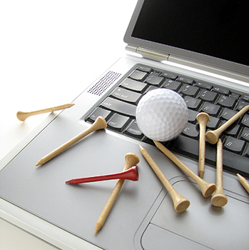 Golf ball and tees on a laptop keyboard.