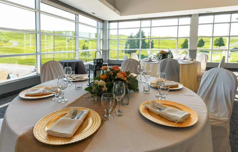 Brown and beige tables with natural centrepieces overlooking the fairway at BraeBen Golf Course