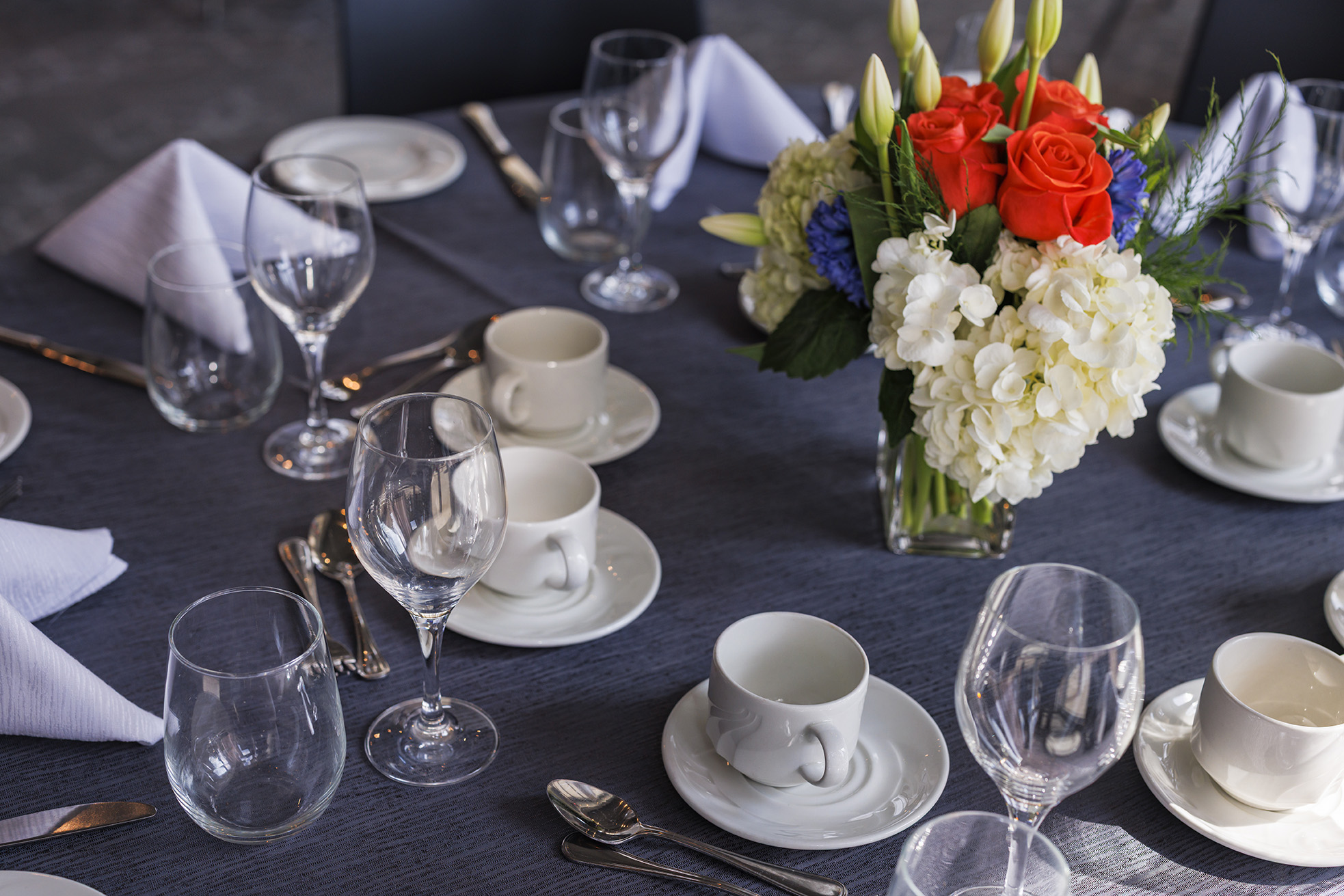 Chairs and tables setup in a theatre style in front of an easel, podium and projector screen