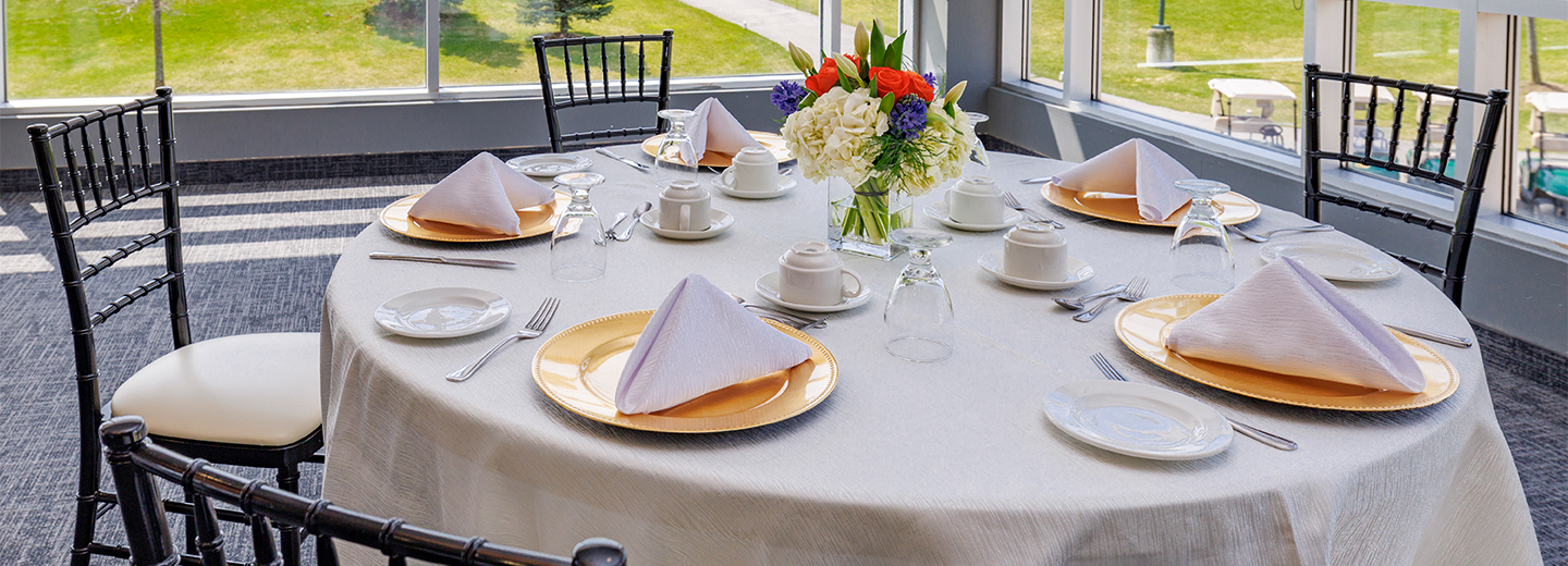 Brown and beige tables with natural centrepieces overlooking the fairway at BraeBen Golf Course